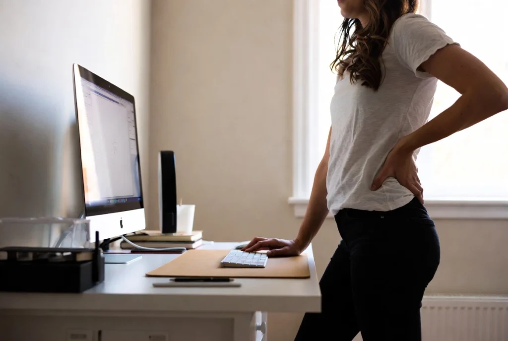Ergonomic standing position at adjustable desk reducing back pain in home office